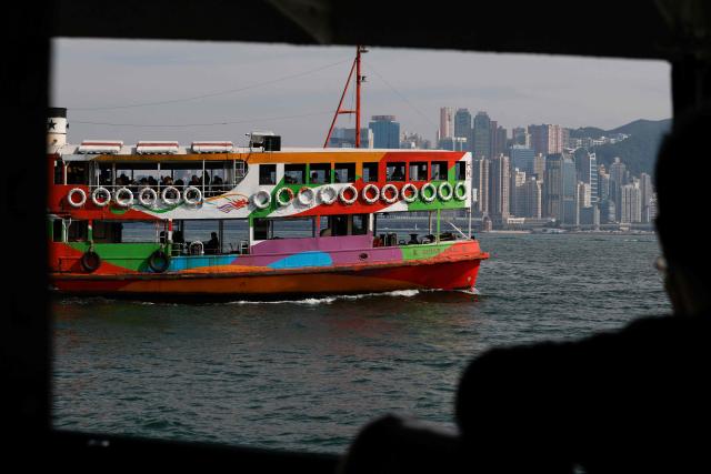 A Star Ferry is seen from another ferry as it sails across Victoria Harbour in Hong Kong on December 22, 2024. (Photo by David GANNON / AFP)