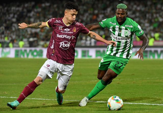 Tolima's Paraguayan forward #27 Gustavo Ramirez and Nacional's forward #27 Dairon Asprilla fight for the ball during the Colombian League second leg football final match between Atletico Nacional and Deportes Tolima at the Atanasio Girardot Stadium in Medellin, Colombia on December 22, 2024. (Photo by Jaime SALDARRIAGA / AFP)