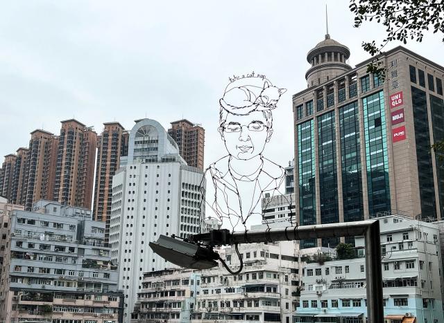 An art creation made of wire is seen attached to a lamppost on a rooftop terrace in Hong Kong on December 23, 2024. (Photo by Mladen ANTONOV and Mladen Antonov / AFP)