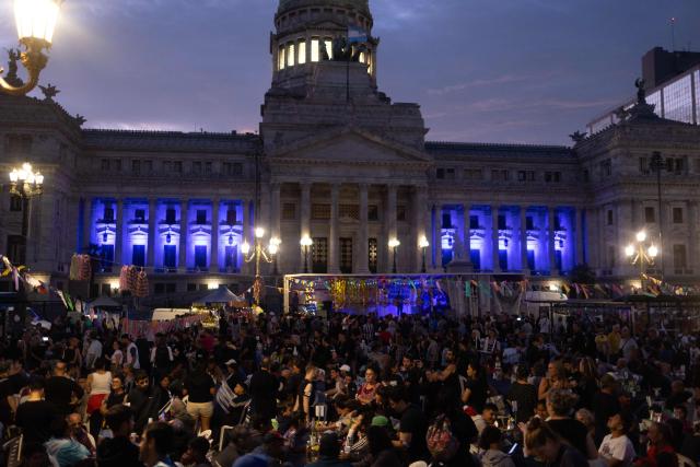 Volunteers and homeless people take part in a Christmas solidarity dinner called 'No Families Without Christmas' in front of the National Congress in Buenos Aires on December 24, 2024. A Christmas solidarity dinner for the homeless gathered in Buenos Aires some three thousand people in front of the National Congress when poverty reaches more than half of the Argentine population after the first year of Javier Milei's ultra-liberal government. (Photo by TOMAS CUESTA / AFP)