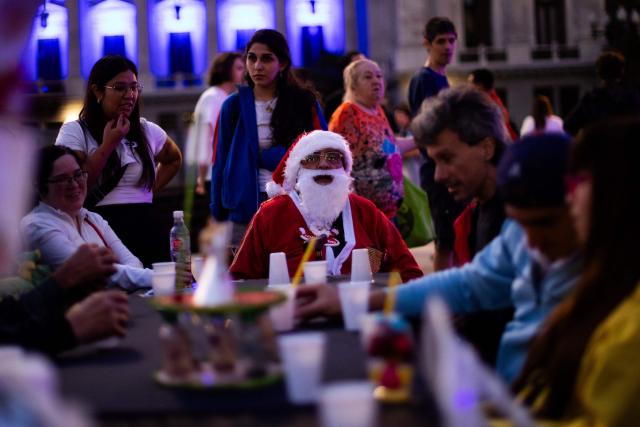 A man dressed as Santa Claus looks on as he takes part in a Christmas solidarity dinner called 'No Families Without Christmas' in front of the National Congress in Buenos Aires on December 24, 2024. A Christmas solidarity dinner for the homeless gathered in Buenos Aires some three thousand people in front of the National Congress when poverty reaches more than half of the Argentine population after the first year of Javier Milei's ultra-liberal government. (Photo by TOMAS CUESTA / AFP)