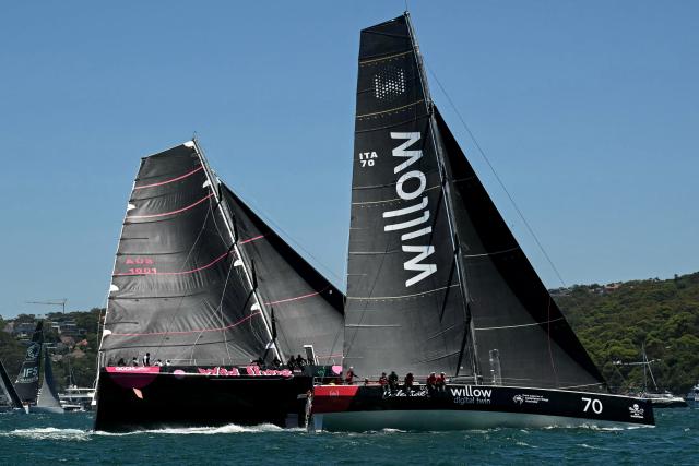 The Wild Thing 100 yacht team competes close to Celestial V70 (R) at the start of the Sydney to Hobart yacht race from Sydney Harbour in Sydney on December 26, 2024. (Photo by Saeed KHAN / AFP)