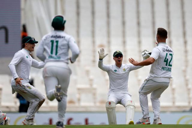 South Africa's Dane Paterson (R) celebrates with teammates after the dismissal of Pakistan's Babar Azam (unseen) during the first day of the first cricket Test match between South Africa and Pakistan at SuperSport Park in Centurion on December 26, 2024. (Photo by PHILL MAGAKOE / AFP)