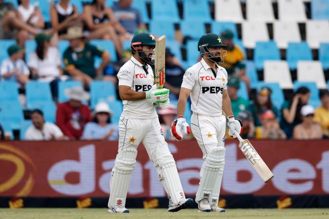 Pakistan's Mohammad Rizwan (L) and Pakistan's Kamran Ghulam return to the creas after the lunch break during the first day of the first cricket Test match between South Africa and Pakistan at SuperSport Park in Centurion on December 26, 2024. (Photo by PHILL MAGAKOE / AFP)