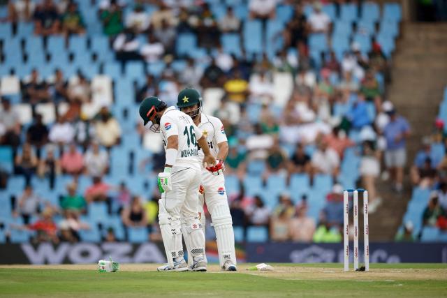 Pakistan's Kamran Ghulam (R) helps Pakistan's Mohammad Rizwan after a ball hit his right hand during a delivery during the first day of the first cricket Test match between South Africa and Pakistan at SuperSport Park in Centurion on December 26, 2024. (Photo by PHILL MAGAKOE / AFP)