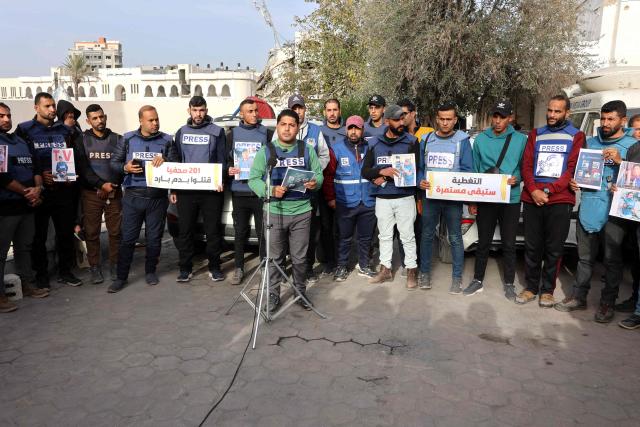 Members of the press stand in solidarity after an Israeli missile hit a media broadcast truck in Nuseirat, on December 26, 2024, outside the Baptist Hospital in Gaza City, amid the ongoing war between Israel and the Palestinian Hamas movement. Palestinian TV channel affiliated with a militant group said five of its journalists were killed on December 26, in an Israeli strike on their vehicle in Gaza, with Israel's military saying it had targeted a "terrorist cell". (Photo by Omar AL-QATTAA / AFP)