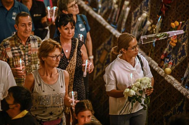 Mourners hold candles as they walk through the Ban Nam Khem Tsunami Memorial Park wall in the southern Thai province of Phang Nga on December 26, 2024. Emotional ceremonies began across Asia on December 26 to remember the 220,000 people who died two decades ago when a tsunami devastated coastal areas around the Indian Ocean, in one of the worst natural disasters in human history. (Photo by Lillian SUWANRUMPHA / AFP)