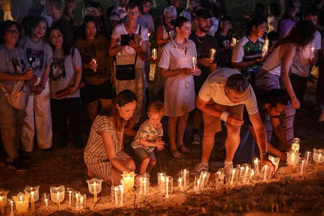 Mourners place candles on the beach at the Ban Nam Khem Tsunami Memorial Park in the southern Thai province of Phang Nga on December 26, 2024. Emotional ceremonies began across Asia on December 26 to remember the 220,000 people who died two decades ago when a tsunami devastated coastal areas around the Indian Ocean, in one of the worst natural disasters in human history. (Photo by Lillian SUWANRUMPHA / AFP)