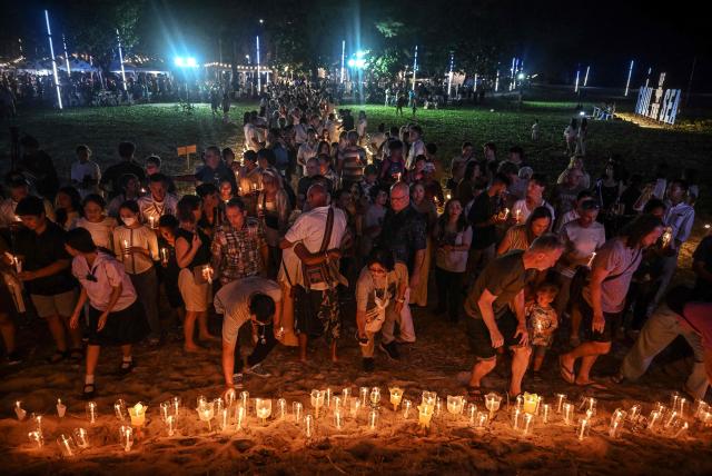 Mourners place candles on the beach at the Ban Nam Khem Tsunami Memorial Park in the southern Thai province of Phang Nga on December 26, 2024. Emotional ceremonies began across Asia on December 26 to remember the 220,000 people who died two decades ago when a tsunami devastated coastal areas around the Indian Ocean, in one of the worst natural disasters in human history. (Photo by Lillian SUWANRUMPHA / AFP)