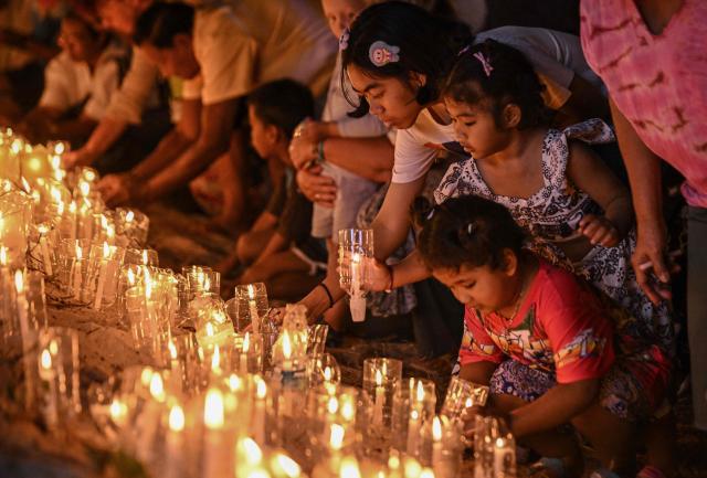 Mourners place candles on the beach at the Ban Nam Khem Tsunami Memorial Park in the southern Thai province of Phang Nga on December 26, 2024. Emotional ceremonies began across Asia on December 26 to remember the 220,000 people who died two decades ago when a tsunami devastated coastal areas around the Indian Ocean, in one of the worst natural disasters in human history. (Photo by Lillian SUWANRUMPHA / AFP)