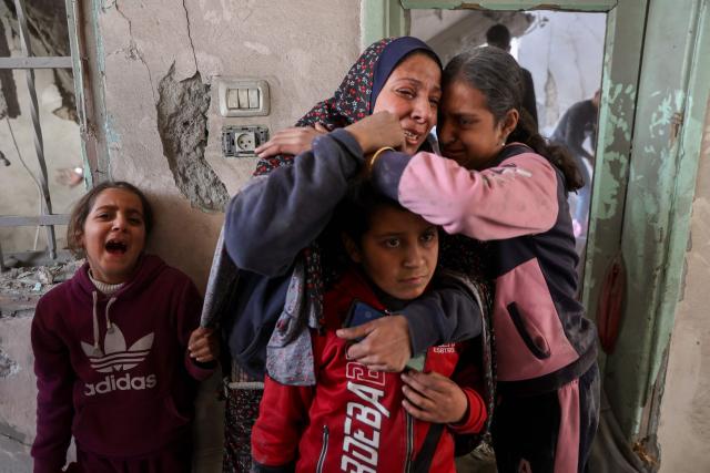 A woman and children react at the site of an Israeli strike in a residential area in the Tuffah neighbourhood, east of Gaza City, on December 26, 2024, amid the ongoing war between Israel and the Palestinian Hamas movement. The health ministry in Hamas-run Gaza said on December 26, that 38 people had been killed in the Palestinian territory in the past 24 hours, taking the overall war death toll to 45,399. (Photo by Omar AL-QATTAA / AFP)