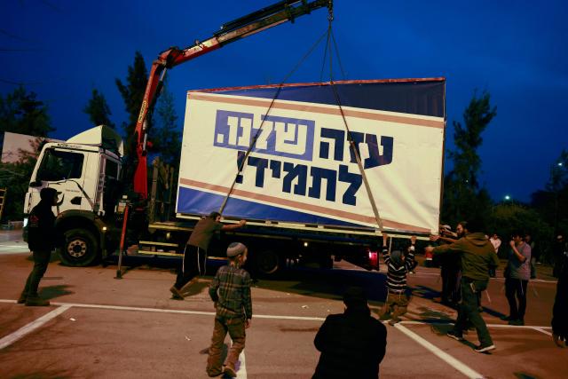 Israeli right-wing activists load a mobile house bearing a slogan which reads in Hebrew "Our Gaza Forever", onto a truck in the southern town of Sderot near the border with Gaza on December 26, 2024, for what they say is establishing a new Jewish settlement in the Gaza Strip, during an activity to promote the idea of settlement in the besieged Palestinian territory amid the ongoing war between Israel and the Palestinian Hamas movement. (Photo by Menahem KAHANA / AFP)