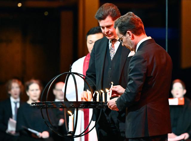 Speaker Andreas Norlen and Prime Minister Ulf Kristersson light candles during a memorial service for the victims of the 2004 tsunami in the Indian Ocean, at the Cathedral in Uppsala, on December 26, 2024. (Photo by Christine Olsson/TT / TT News Agency / AFP) / Sweden OUT