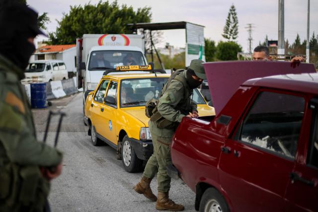 Fighters affiliated with Syria's new administration inspect a car at a checkpoint in Syria's western coastal city of Latakia on December 26, 2024. Syria's new authorities launched an operation in a stronghold of ousted president Bashar al-Assad on December 26, with a war monitor saying three gunmen affiliated with the former government were killed, a day after angry protests erupted in several areas around Syria over a video showing an attack on an Alawite shrine that circulated online. (Photo by Aaref WATAD / AFP)