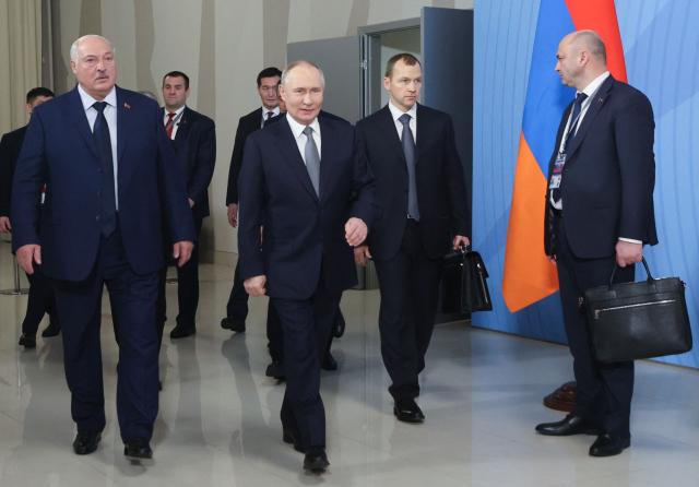 In this pool photograph distributed by the Russian state agency Sputnik, Russia's President Vladimir Putin and Belarus' President Alexander Lukashenko walk after a meeting of the Supreme Eurasian Economic Council at Igora ski resort in the Leningrad region on December 26, 2024. (Photo by Dmitry Demyanenko / POOL / AFP)