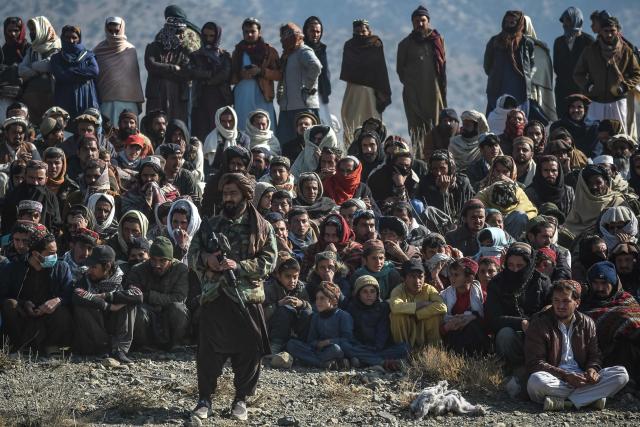 A Taliban security personnel stands guard as residents gather at the site two days after air strikes by Pakistan in the Barmal district of eastern Paktika province on December 26, 2024. Pakistan air strikes in an eastern border region of Afghanistan killed 46 civilians, the Taliban government said on December 25, whilst a Pakistan security official said the bombardment had targeted "terrorist hideouts". (Photo by Ahmad SAHEL ARMAN / AFP)