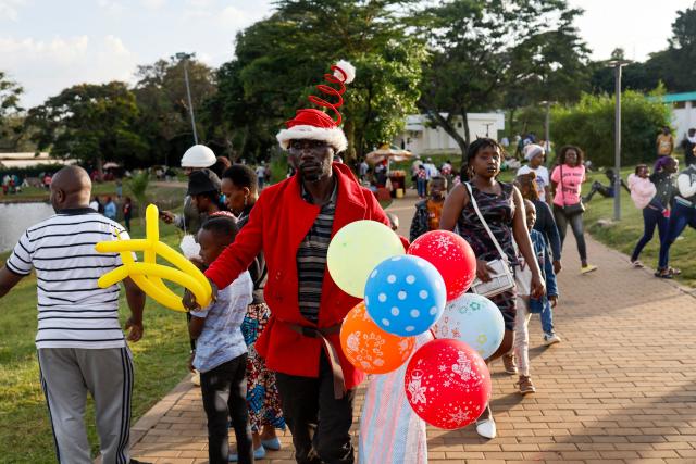 A man sells balloons as people walk through Uhuru Park on Boxing Day, in Nairobi, on December 26, 2024. (Photo by SIMON MAINA / AFP)