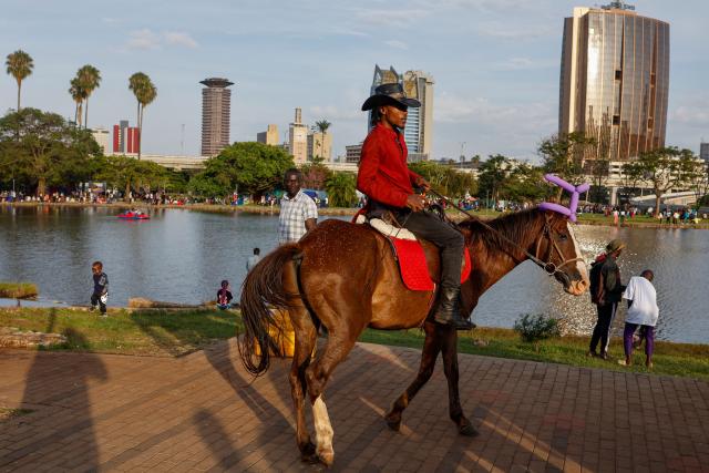 A man rides a horse through Uhuru Park on Boxing Day, in Nairobi, on December 26, 2024. (Photo by SIMON MAINA / AFP)