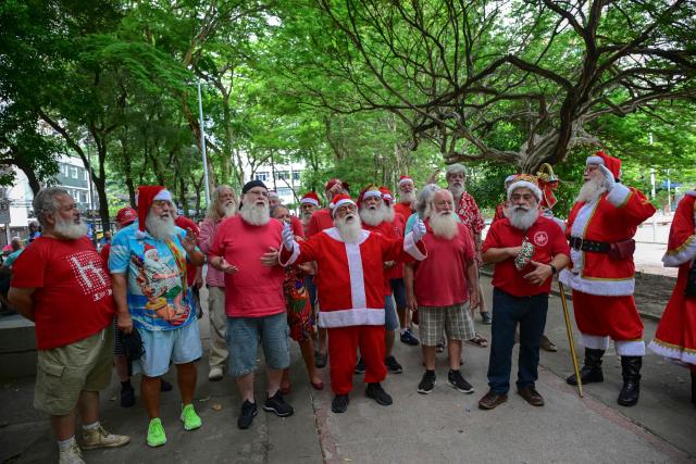 A group of professional Santas from Brazil's Santa Claus School participates in an annual event called "Barbas de Molho" (Beards at Rest) in Rio de Janeiro, Brazil, on December 26, 2024. The meeting is a tradition of the group to celebrate the end of the Christmas season. (Photo by Mauro PIMENTEL / AFP)