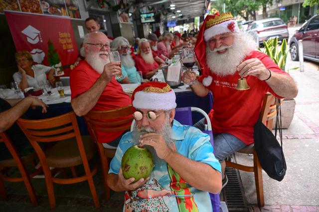 A group of professional Santas from Brazil's Santa Claus School poses for a picture during an annual event called "Barbas de Molho" (Beards at Rest) at a restaurant in Rio de Janeiro, Brazil, on December 26, 2024. The meeting is a tradition of the group to celebrate the end of the Christmas season. (Photo by Mauro PIMENTEL / AFP)