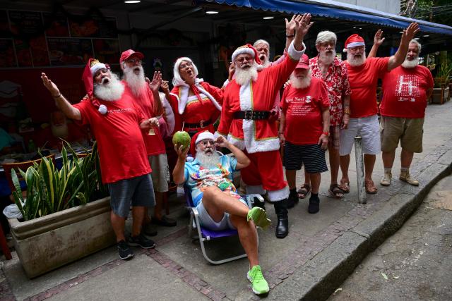 A group of professional Santas from Brazil's Santa Claus School participates in an annual event called "Barbas de Molho" (Beards at Rest) at a restaurant in Rio de Janeiro, Brazil, on December 26, 2024. The meeting is a tradition of the group to celebrate the end of the Christmas season. (Photo by Mauro PIMENTEL / AFP)