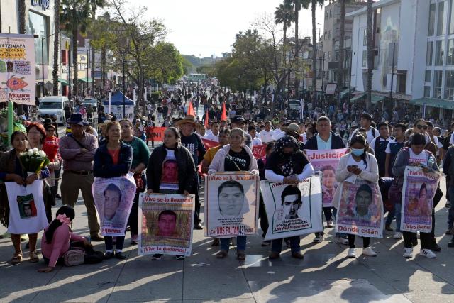 Relatives of the Ayotzinapa victims hold portraits of the missing students as they take part in a pilgrimage in front of the Basilica of Our Lady of Guadalupe to demand justice in the case of the Ayotzinapa missing students in Mexico City on December 26, 2024. 26 September marked 10 years since the enforced disappearance of 43 students from the Ayotzinapa Rural Normal School. (Photo by ALFREDO ESTRELLA / AFP)