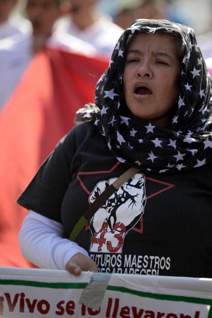 A relative of the Ayotzinapa victims shouts as she takes part in a pilgrimage in front of the Basilica of Our Lady of Guadalupe to demand justice in the case of the Ayotzinapa missing students in Mexico City on December 26, 2024. 26 September marked 10 years since the enforced disappearance of 43 students from the Ayotzinapa Rural Normal School. (Photo by ALFREDO ESTRELLA / AFP)