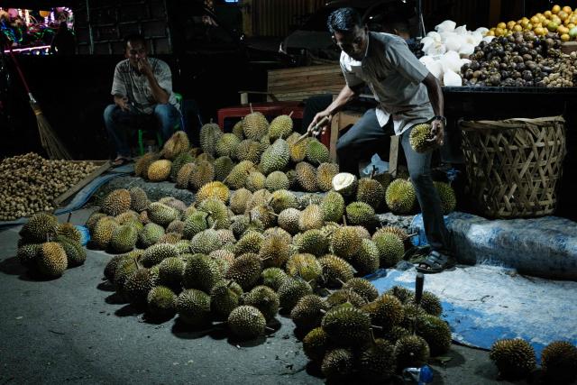 A man sells durians on a street in Banda Aceh on December 26, 2024. (Photo by Yasuyoshi CHIBA / AFP)