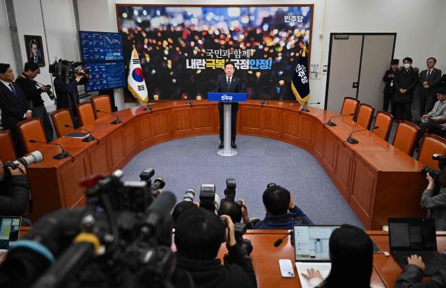 South Korea's main opposition Democratic Party leader Lee Jae-myung delivers a public statement on the impeachment motion against acting president Han Duck-soo at the National Assembly in Seoul on December 27, 2024. South Korea's acting president Han faced an impeachment vote on December 27, as the country struggled to shake off political turmoil sparked by his predecessor's martial law declaration that shocked the world. (Photo by JUNG YEON-JE / AFP)