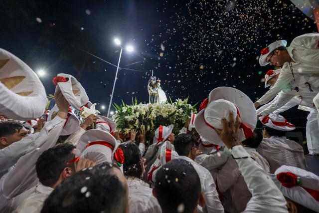 TOPSHOT - A group of men carry an image of Saint Benedict as they participate in the cultural and religious celebration Marujada, a traditional festival that pays homage to Saint Benedict (Sao Benedito) in the city of Bragança, Para State, Brazil, on December 26, 2024. Cultural heritage of Brazil, the Marujada is a traditional festival that pays homage to Saint Benedict, the "black saint," and has one of its highlights on Christmas Day, during the feast that lasts nine days until December 26. (Photo by Anderson Coelho / AFP)