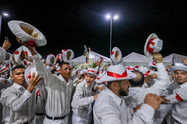 A group of men gesture as they take part in the cultural and religious celebration Marujada, a traditional festival that pays homage to Saint Benedict (Sao Benedito) in the city of Bragança, Para State, Brazil, on December 26, 2024. Cultural heritage of Brazil, the Marujada is a traditional festival that pays homage to Saint Benedict, the "black saint," and has one of its highlights on Christmas Day, during the feast that lasts nine days until December 26. (Photo by Anderson Coelho / AFP)