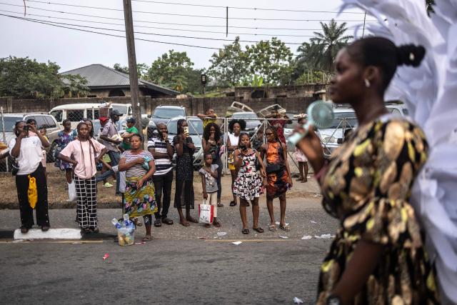 Residents look at the Calabar Carnival's parade in Calabar on December 28, 2024. Calabar Carnival is an annual carnival held in Cross River State, Nigeria: it is celebrated every December to mark Christmas celebration yearly. The quality of the festival has grown over the years making it Nigeria's biggest carnival and an internationally recognized festival. (Photo by OLYMPIA DE MAISMONT / AFP)