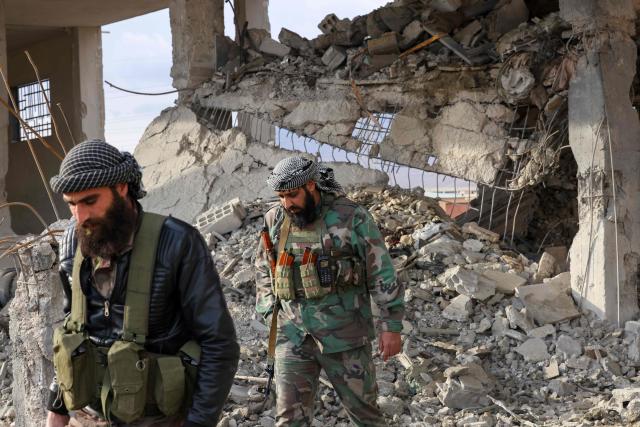 Fighters affiliated with Syria's new administration inspect the damage at the site of an explosion at a weapons depot the previous day at the Industrial area of Adra, some 30 kilometres from the Syrian capital Damascus on December 30, 2024. An official from a nearby area, requesting anonymity, told AFP on December 29 that "an explosion of unknown origin" rocked the Adra industrial area, reporting an unspecified number of casualties and adding that rescue operations were ongoing. (Photo by ANWAR AMRO / AFP)