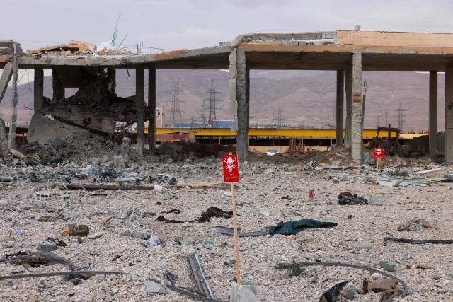 TOPSHOT - Signs warning of the presence of unexploded ordnance are displayed at the site of an explosion at a weapons depot the previous day at the Industrial area of Adra, some 30 kilometres from the Syrian capital Damascus on December 30, 2024. An official from a nearby area, requesting anonymity, told AFP on December 29 that "an explosion of unknown origin" rocked the Adra industrial area, reporting an unspecified number of casualties and adding that rescue operations were ongoing. (Photo by ANWAR AMRO / AFP)