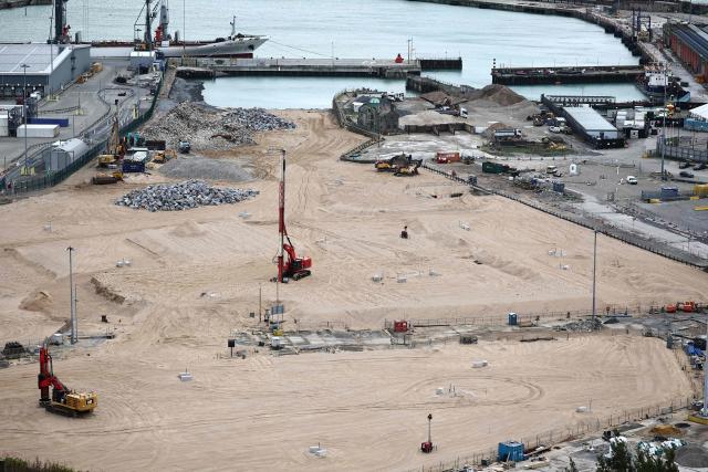 Construction vehicles are pictured parked on sand, that has been used to fill docks at the harbour at the Port of Dover, on the southeast coast of England on December 30, 2024. (Photo by HENRY NICHOLLS / AFP)