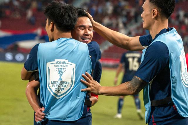 Thailand's forward Suphanat Mueanta (C) celebrates with teammates after scoring a goal during the 2024 ASEAN Electric Cup semi-final second leg football match between Thailand and the Philippines at the Rajamangala National Stadium in Bangkok on December 30, 2024. (Photo by Chanakarn Laosarakham / AFP)