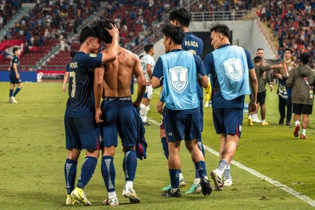 Thailand's forward Suphanat Mueanta (2L) celebrates with Thailand's forward Supachok Sarachat (L) and teammates after scoring a goal during the 2024 ASEAN Electric Cup semi-final second leg football match between Thailand and the Philippines at the Rajamangala National Stadium in Bangkok on December 30, 2024. (Photo by Chanakarn Laosarakham / AFP)