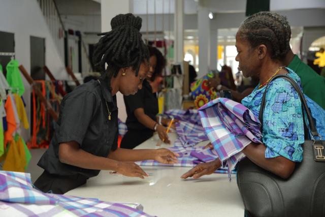 National Democratic Party (NDP) supporters buy the official pangi fabrics in the NDP party's purple colors as a tribute for the funeral of NDP honorary chairman and former Suriname PPresident, Desi Bouterse, at the Majeeda store in Paramaribo on December 30, 2024. The government of Suriname announced on December 28 that former President Desi Bouterse, who died while on the run from justice, will not receive a state funeral, said Foreign Minister Albert Ramdin. (Photo by Ranu Abhelakh / AFP)