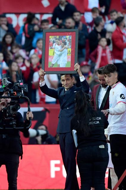 Sevilla's Spanish defender Jesus Navas holds a picture of him with late Sevilla's and international player Jose Antonio Reyes during his farewell ceremony, at the Ramon Sanchez Pizjuan stadium in Sevilla on December 30, 2024. Navas retires after two decades marked by numerous titles with the Sevilla FC and the 2010 FIFA World Cup in South Africa with Spain's national team. (Photo by CRISTINA QUICLER / AFP)