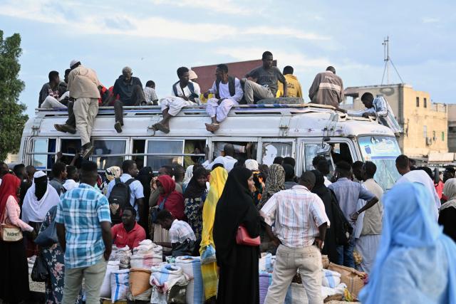 People struggling to commute gather around a packed bus in Port Sudan as local transportation is strangled after government authorities reportedly changed two currency notes, invalidating old notes, on December 30, 2024, in the army-controlled Red Sea city city, where the government loyal to the army is based. Sudan is reeling from 20 months of fighting between the Sudanese army and the paramilitary Rapid Support Forces, led by rival generals, which have led to a dire humanitarian crisis. The war since April 2023 has killed tens of thousands of people and uprooted 12 million, creating what the United Nations has called the world's largest displacement crisis. (Photo by AFP)