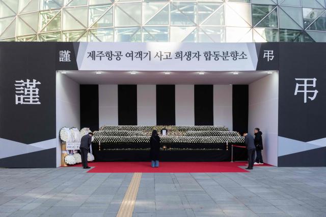 People pay their respects at the altar in front of Seoul City Hall in memory of the victims of the Jeju Air plane crash, in Seoul on December 31, 2024. The Boeing 737-800 was carrying 181 people from Thailand to South Korea when it crashed on arrival on December 29, killing everyone aboard -- save two flight attendants pulled from the twisted wreckage of the worst aviation disaster on South Korean soil. (Photo by Roland DE COURSON / AFP)