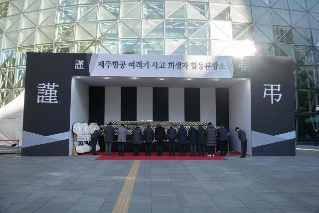 People pay their respects at the altar in front of Seoul City Hall in memory of the victims of the Jeju Air plane crash, in Seoul on December 31, 2024. The Boeing 737-800 was carrying 181 people from Thailand to South Korea when it crashed on arrival on December 29, killing everyone aboard -- save two flight attendants pulled from the twisted wreckage of the worst aviation disaster on South Korean soil. (Photo by Roland DE COURSON / AFP)