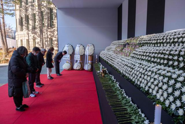 People pay their respects at the altar in front of Seoul City Hall in memory of the victims of the Jeju Air plane crash, in Seoul on December 31, 2024. The Boeing 737-800 was carrying 181 people from Thailand to South Korea when it crashed on arrival on December 29, killing everyone aboard -- save two flight attendants pulled from the twisted wreckage of the worst aviation disaster on South Korean soil. (Photo by Roland DE COURSON / AFP)