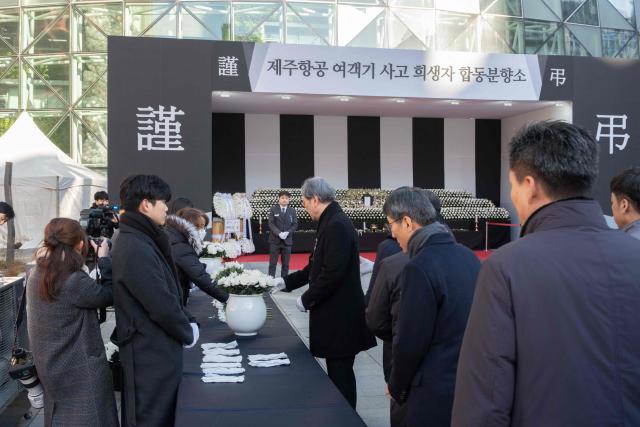 People collect flowers before placing them in front of the altar set up in front of Seoul City Hall in memory of the victims of the Jeju Air plane crash, in Seoul on December 31, 2024. The Boeing 737-800 was carrying 181 people from Thailand to South Korea when it crashed on arrival on December 29, killing everyone aboard -- save two flight attendants pulled from the twisted wreckage of the worst aviation disaster on South Korean soil. (Photo by Roland DE COURSON / AFP)