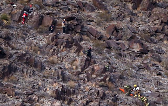 Firefighters and paramedics recover the body of a murdered National Institute of Migration (INM) agent, on a hill near the Precos military checkpoint in the town of Samalayuca, municipality of Juarez, Chihuahua State, Mexico, on December 30, 2024. A Mexican immigration agent was killed on Monday in Juarez, on the US border, after asking a group of migrants to identify themselves, authorities said. (Photo by Herika MARTINEZ / AFP)