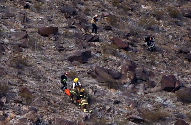 Firefighters and paramedics recover the body of a murdered National Institute of Migration (INM) agent, on a hill near the Precos military checkpoint in the town of Samalayuca, municipality of Juarez, Chihuahua State, Mexico, on December 30, 2024. A Mexican immigration agent was killed on Monday in Juarez, on the US border, after asking a group of migrants to identify themselves, authorities said. (Photo by Herika MARTINEZ / AFP)