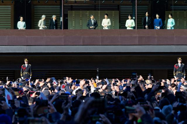 Japan's Emperor Naruhito (4th L) gives a speech as Empress Masako (5th L), their daughter Princess Aiko (4th R) and other imperial family members look on from a balcony during the traditional New Year's greetings at the Imperial Palace in Tokyo on January 2, 2025. (Photo by Zhang Xiaoyu / POOL / AFP)