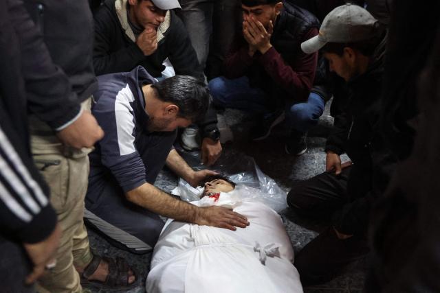 People mourn over the body of a loved one killed in an Israeli strike, at Al-Ahli Arab hospital, also known as the Baptist hospital, in Gaza City on January 2, 2025, amid the continuing war between Israel and the militant Hamas group. (Photo by Omar AL-QATTAA / AFP)