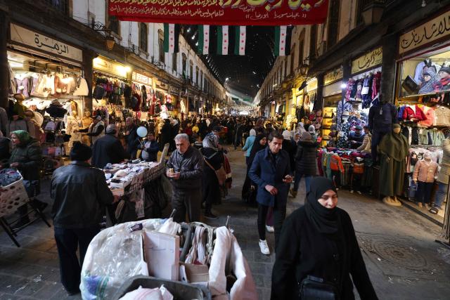 People walk at the Hamidiyah market in the old city of the capital Damascus on January 2, 2025. (Photo by ANWAR AMRO / AFP)