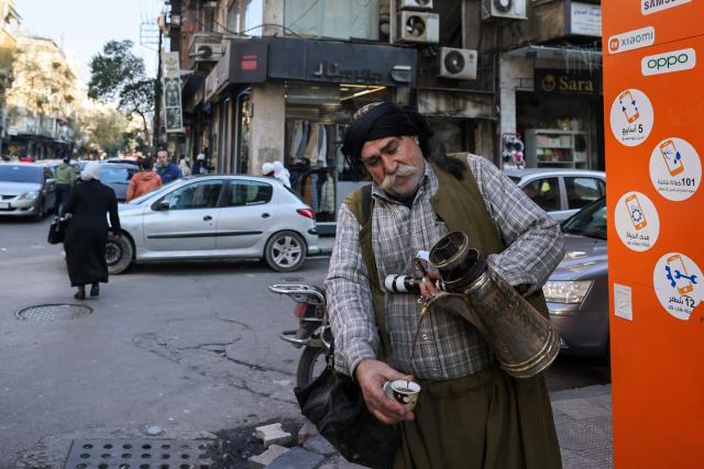 A man sells coffee in the al-Shalaan area in central Damascus on January 2, 2025. (Photo by ANWAR AMRO / AFP)